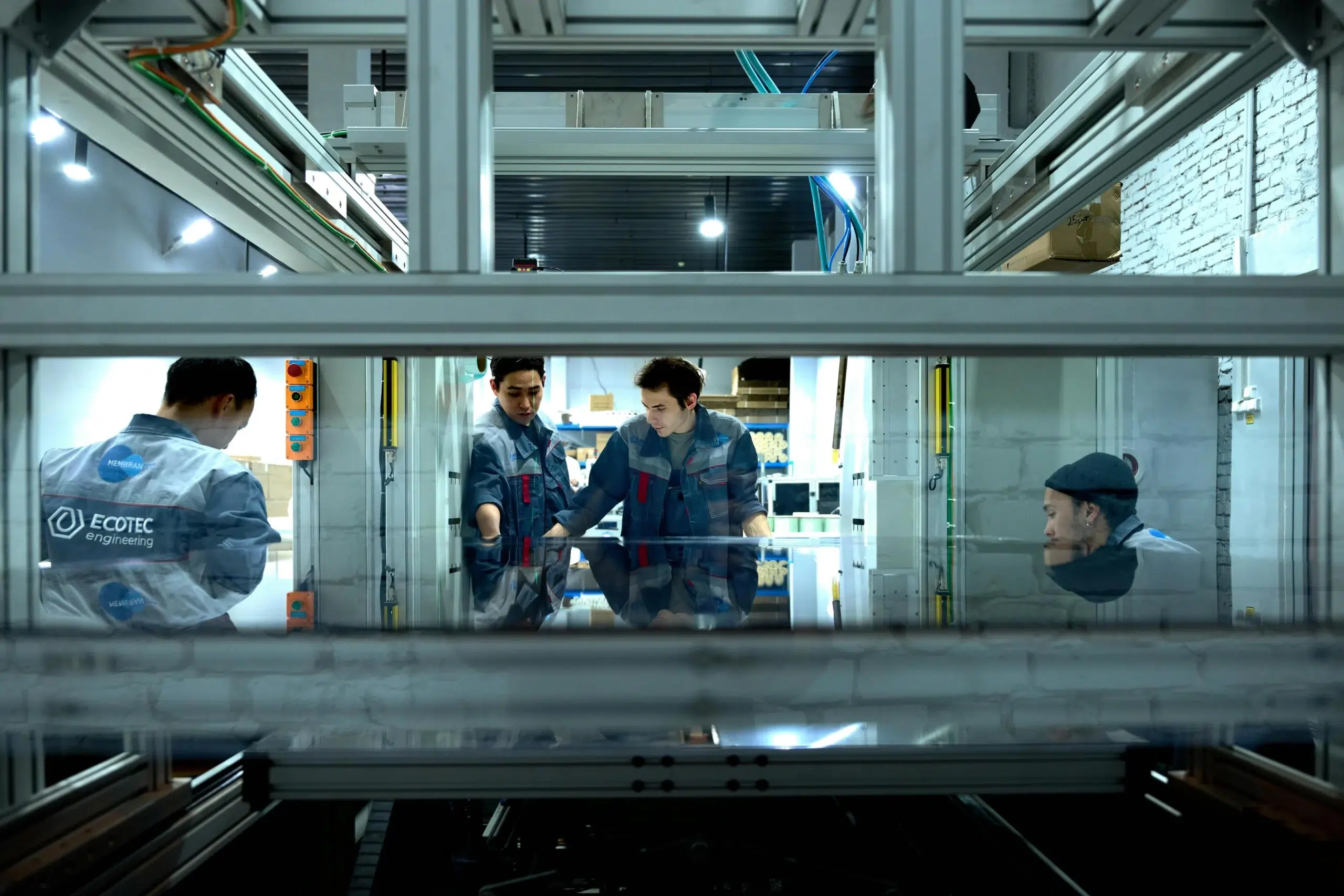 Manufacturing maintenance team inspecting industrial equipment inside a production facility