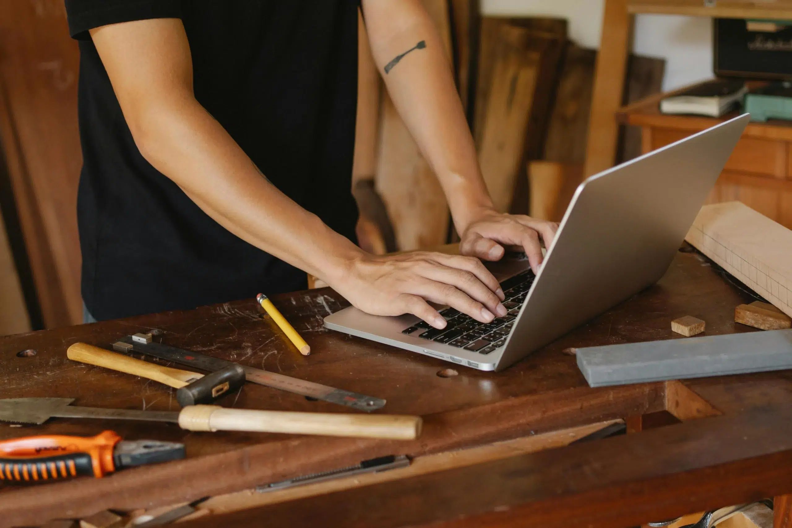A technician using a laptop on a workshop bench, demonstrating the transition from spreadsheet-based tracking to a secure on-premise industrial maintenance management system.
